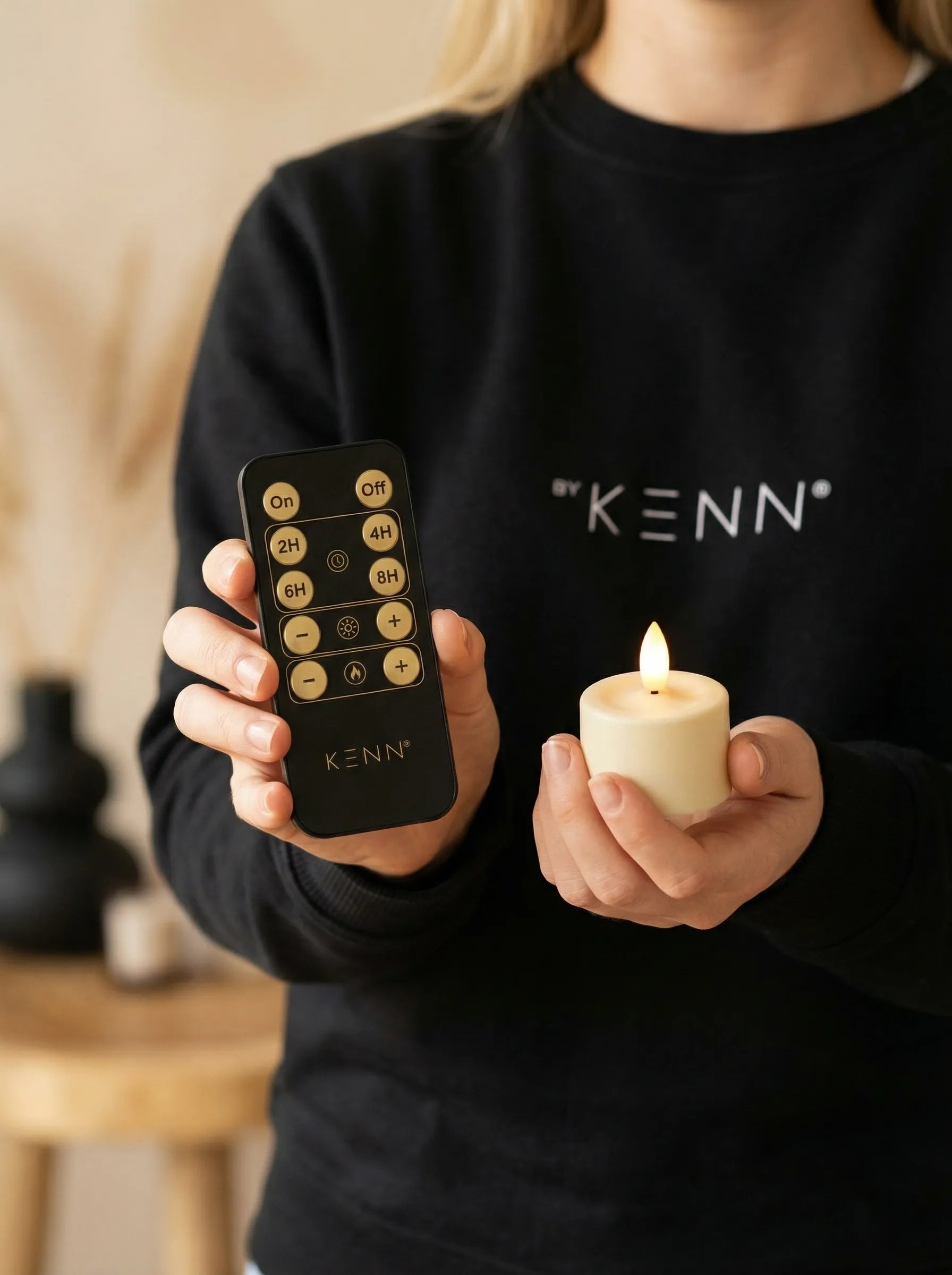 BYKENN medewerker houdt realistisch flikkerend GlowPro™ oplaadbaar waxinelichtje vast met afstandsbediening.