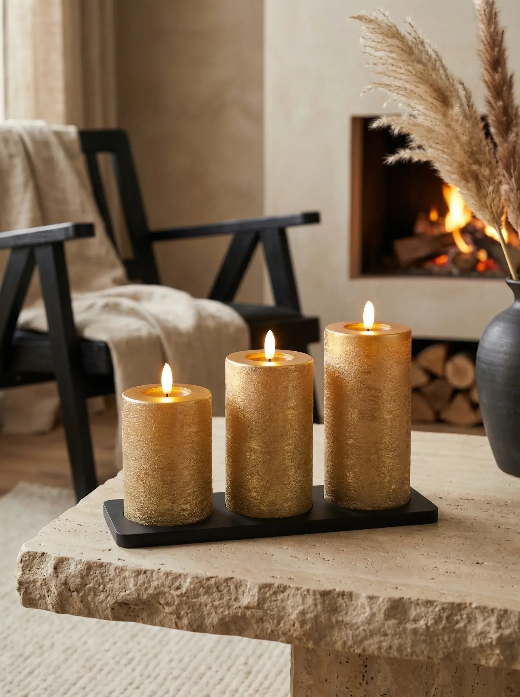 KENN® GlowPro™ Set van 3 goudgekleurde oplaadbare stompkaarsen met laadstation in een gezellige woonkamer met haard.